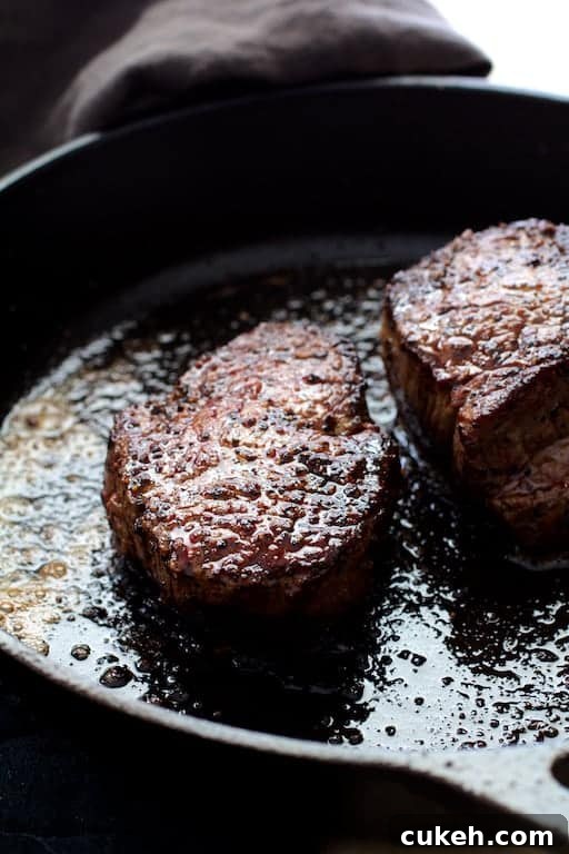 Beef Tenderloin Fillets with Spinach-Stuffed Portobello Mushrooms 5 Photo of two seared beef fillets in cast iron skillet.