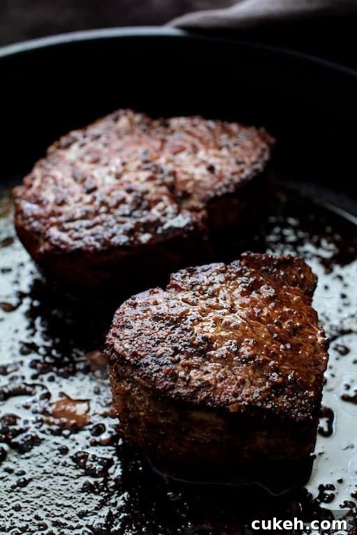 Beef Tenderloin Fillets with Spinach-Stuffed Portobello Mushrooms 6 Photo of two seared fillets in cast iron skillet.