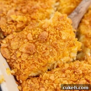 Lifting a square of hash brown casserole from a baking dish.