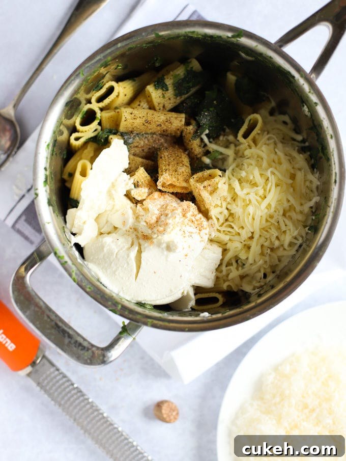 Saucepan with vegetables, and cheese ready to be mixed.
