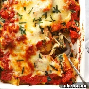A dish with cooked Spinach and Ricotta Pasta Bake, topped with cheese, ready to be served.