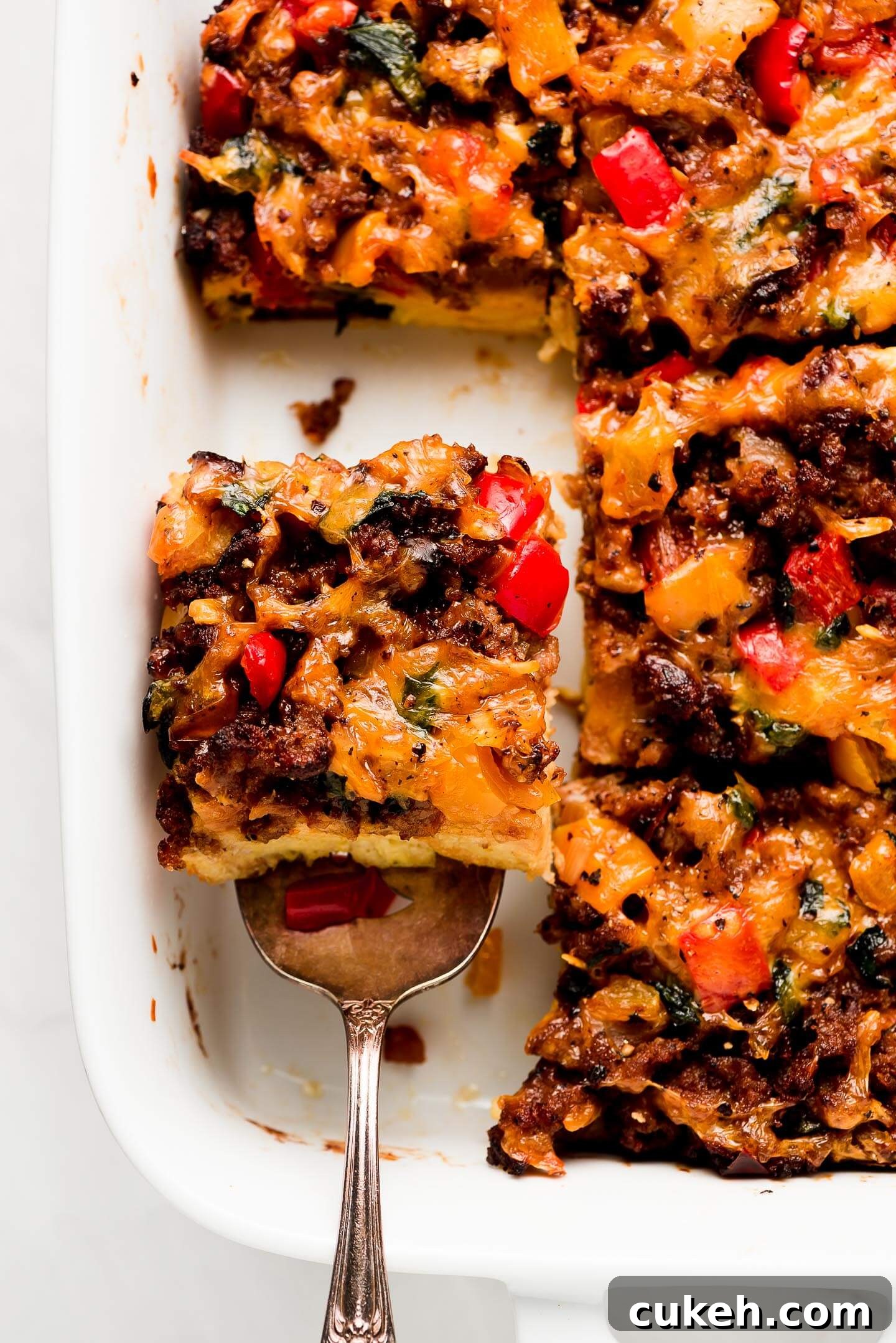 Lifting an egg and sausage breakfast casserole out of baking dish.