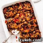 White dish of squares of egg and sausage breakfast casserole.