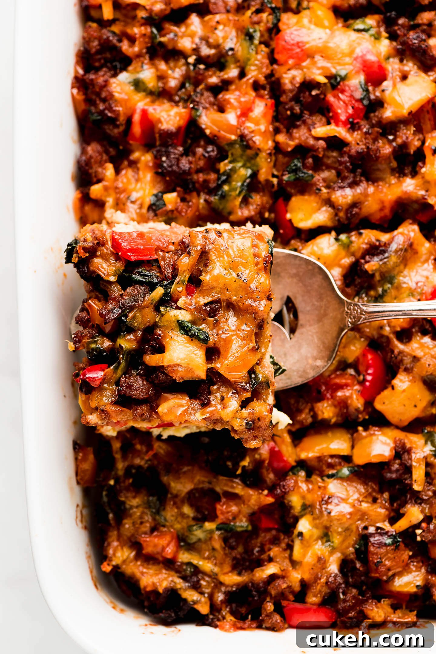 A square of breakfast casserole being lifted out of pan.