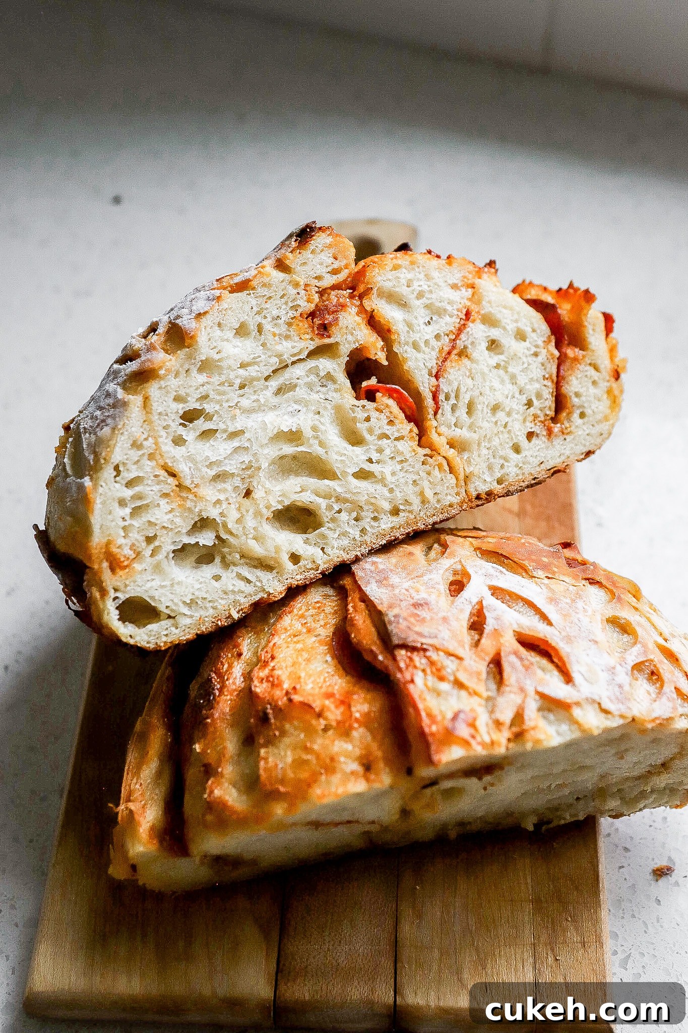Side view of homemade pepperoni pizza sourdough bread stacked on top of one another.