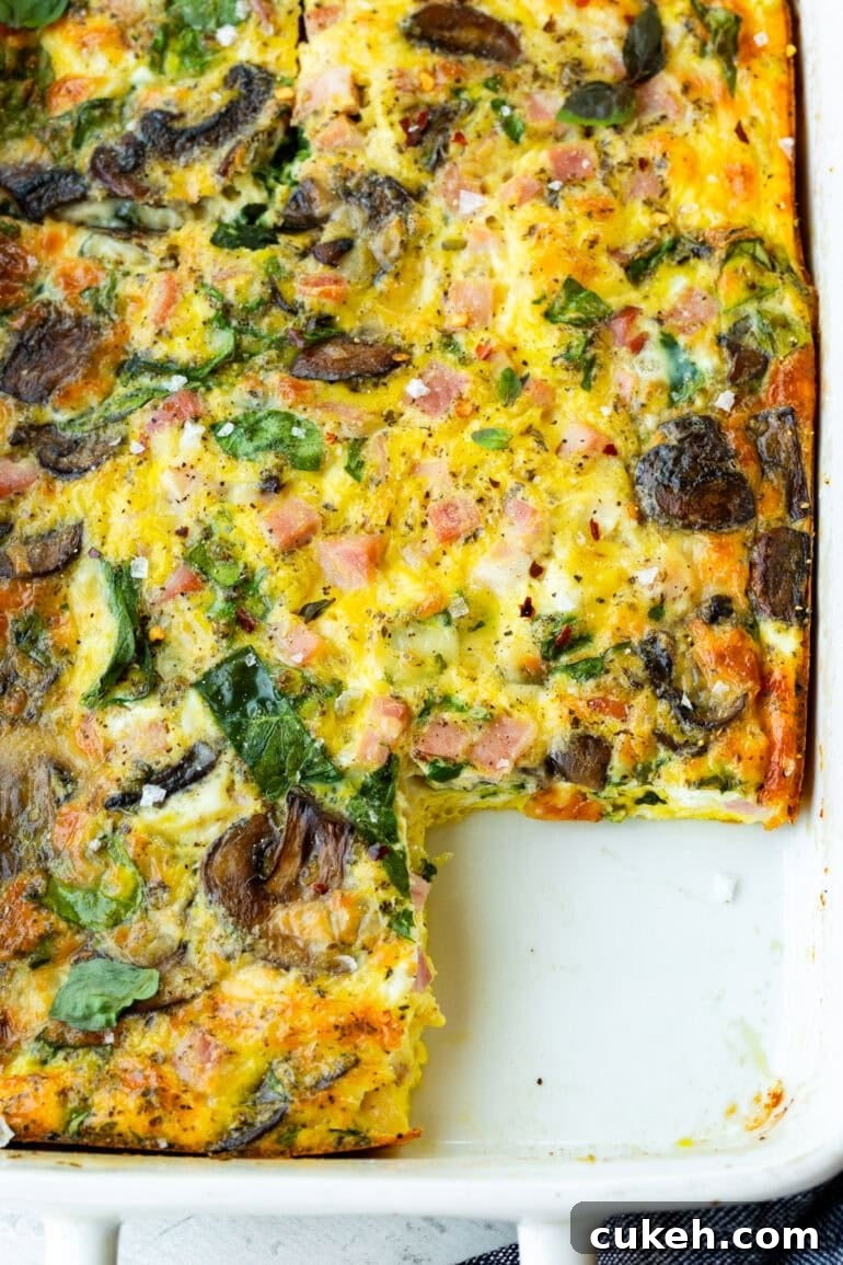 a baked breakfast egg casserole with a piece missing 