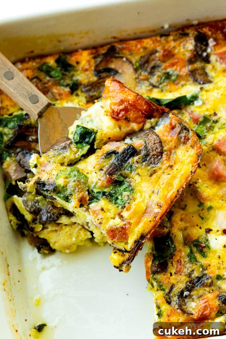 a spatula lifting a piece of breakfast egg casserole from a pan