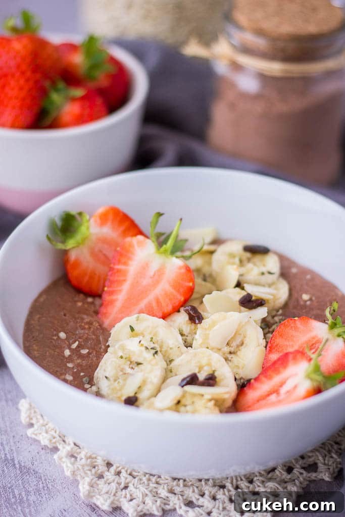 Chocolate oatmeal breakfast bowl served with fresh strawberries and banana
