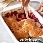 close up image of scooping out fruit cobbler to fit the recipe card