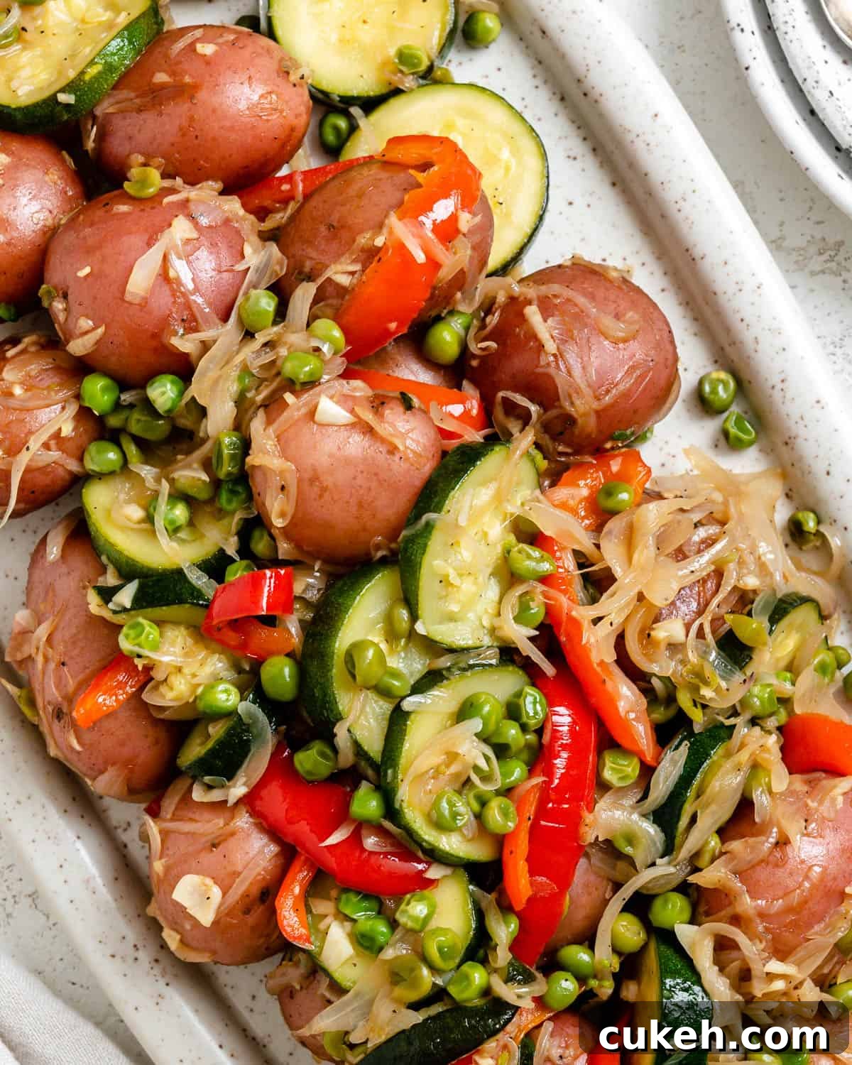 Sautéed Baby Potatoes and Mixed Vegetables Skillet 10 completed Sautéed Mixed Vegetables with Baby Potatoes plated on a white platter against a light background