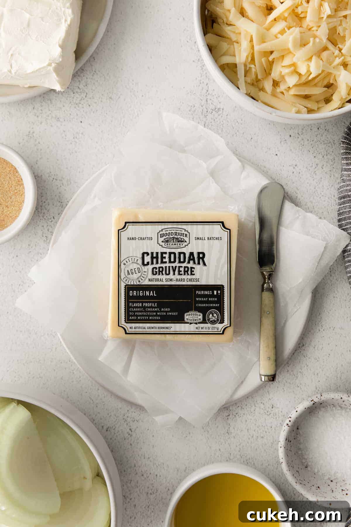 Wood River Creamery Cheddar Gruyere used in this recipe Wood river creamery cheddar gruyere block of cheese next to a cheese knife.