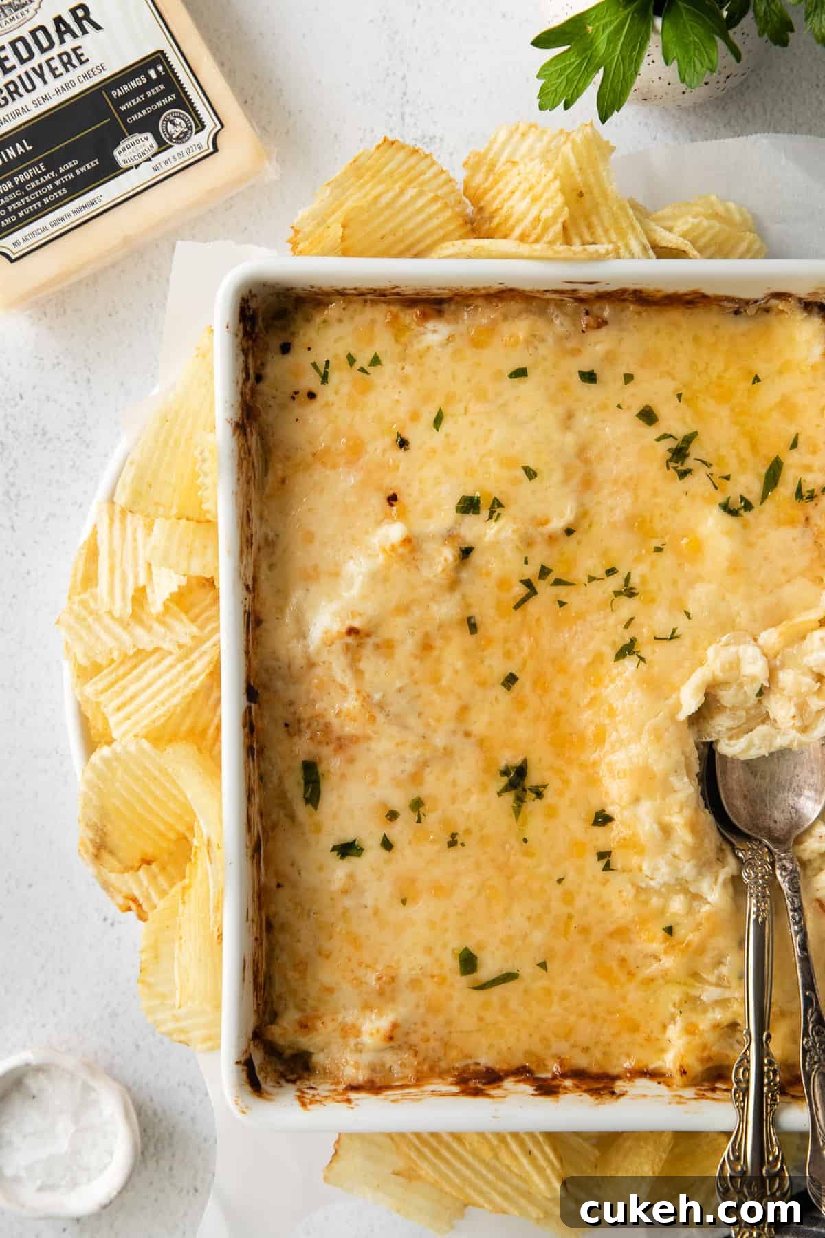 Finished French onion dip topped with parsley French onion dip in a casserole dish topped with fresh parsley.