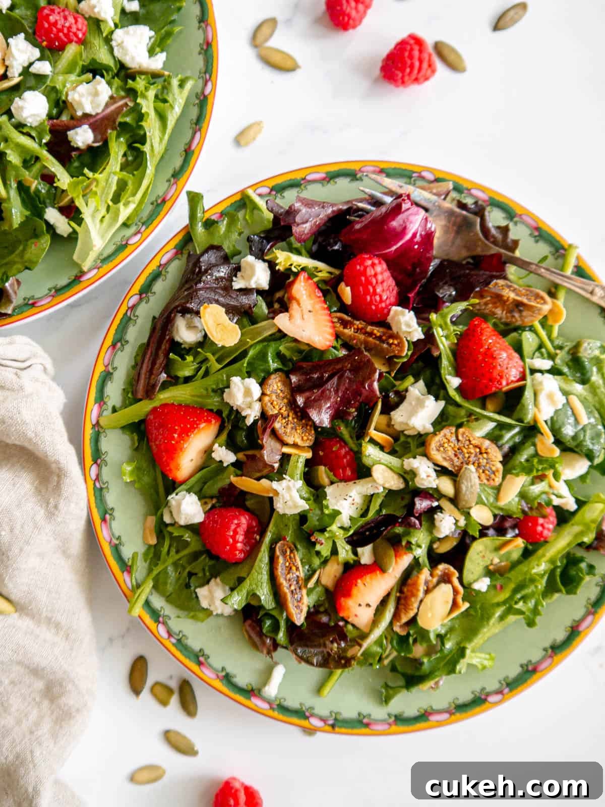 Berry and fig salad on a plate, topped with goat cheese.