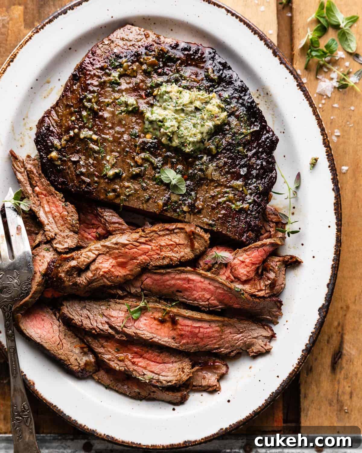 Overhead image of cast iron flank steak with garnish.