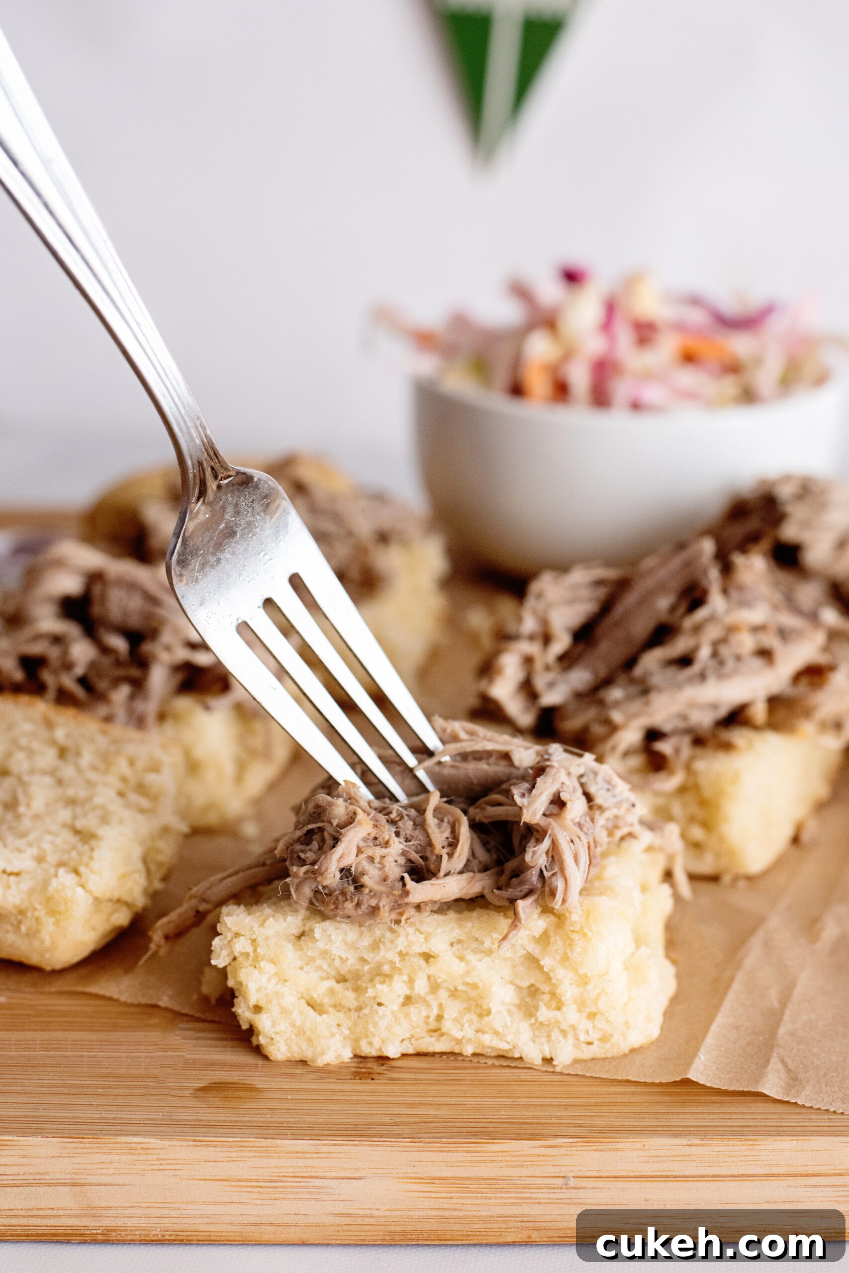 Placing pulled pork on slider.