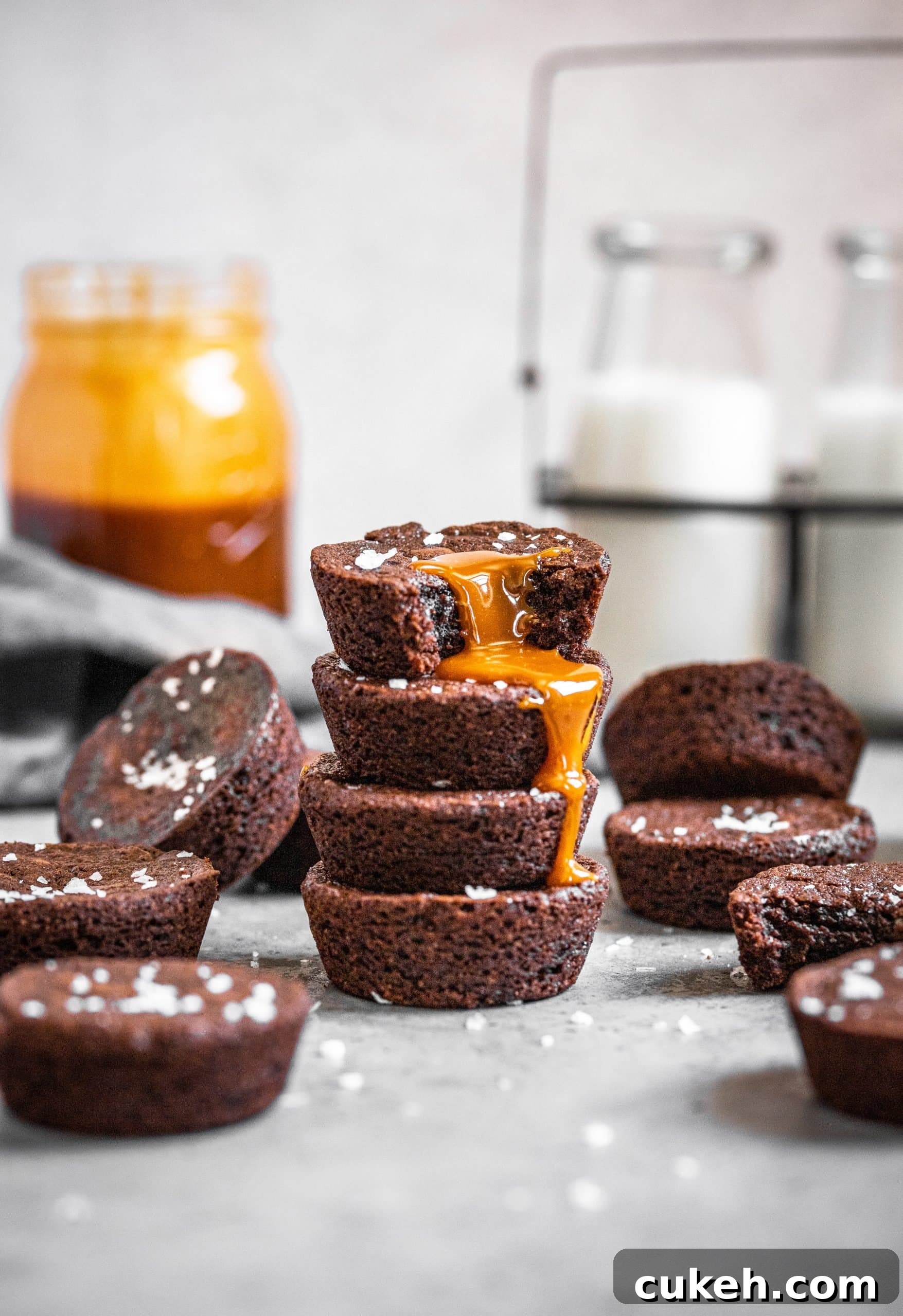 A stack of Muffin Tin Brownie Bites with Salted Caramel Sauce dripping down the side