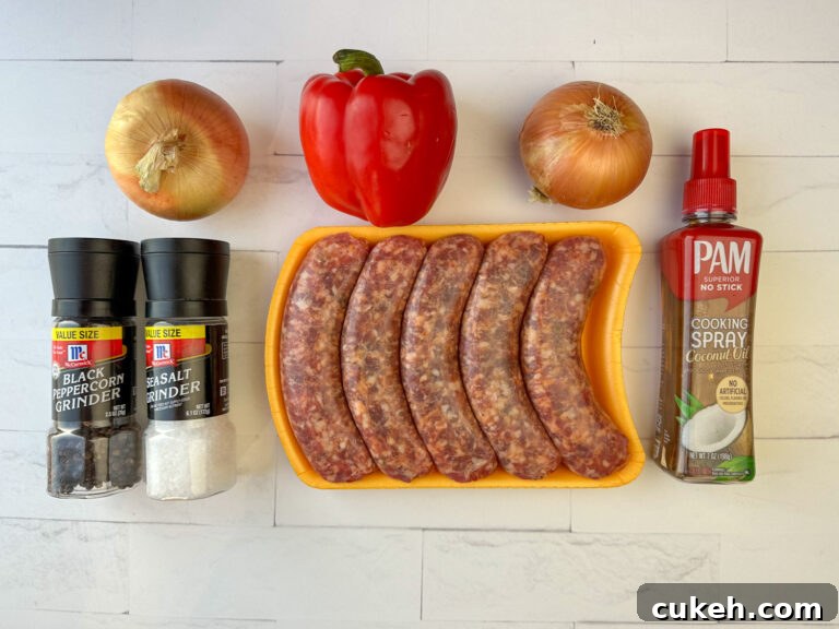 Ingredients need to make Air Fryer Italian sausage are onions, a red bell pepper, black pepper, salt, a tray of Italian sausages and cooking spray on a white counter top.