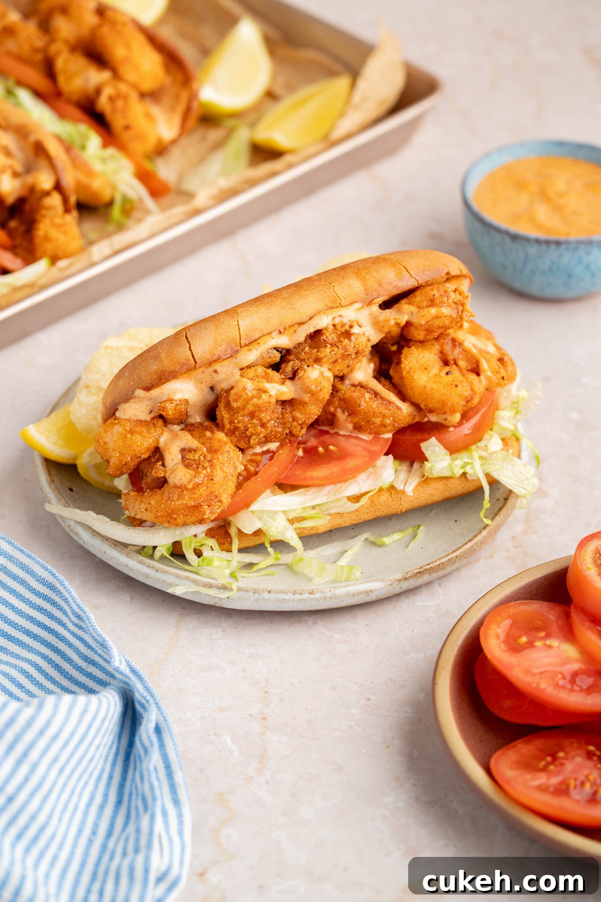 The final shrimp po' boy assembled on a plate for serving.