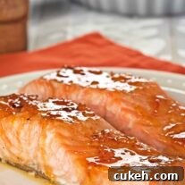 Orange Marmalade Bourbon-Glazed Salmon Recipe for Dinner 4 Orange marmalade and bourbon glazed salmon fillets coated in a glossy citrus glaze on a white plate.