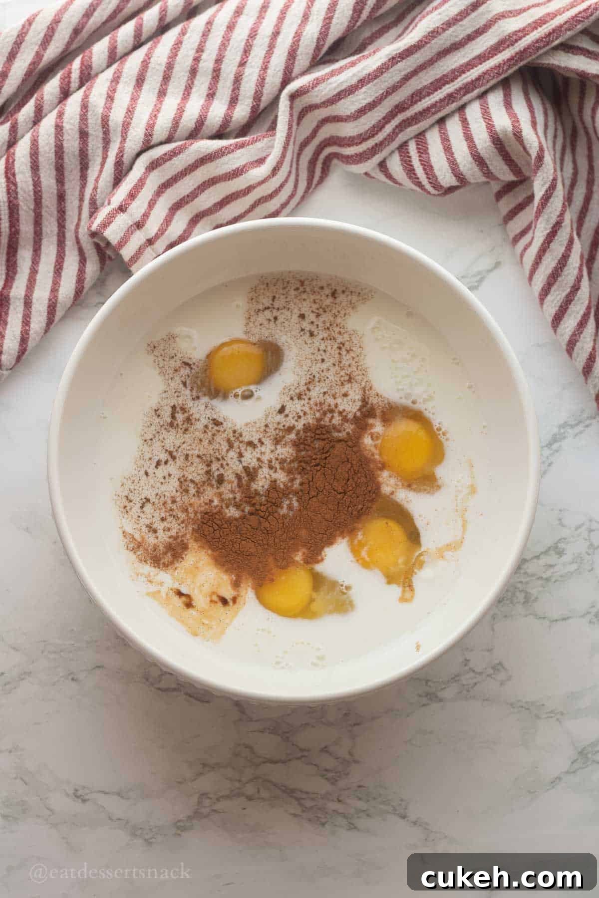 Eggs, milk, and spices in bowl.
