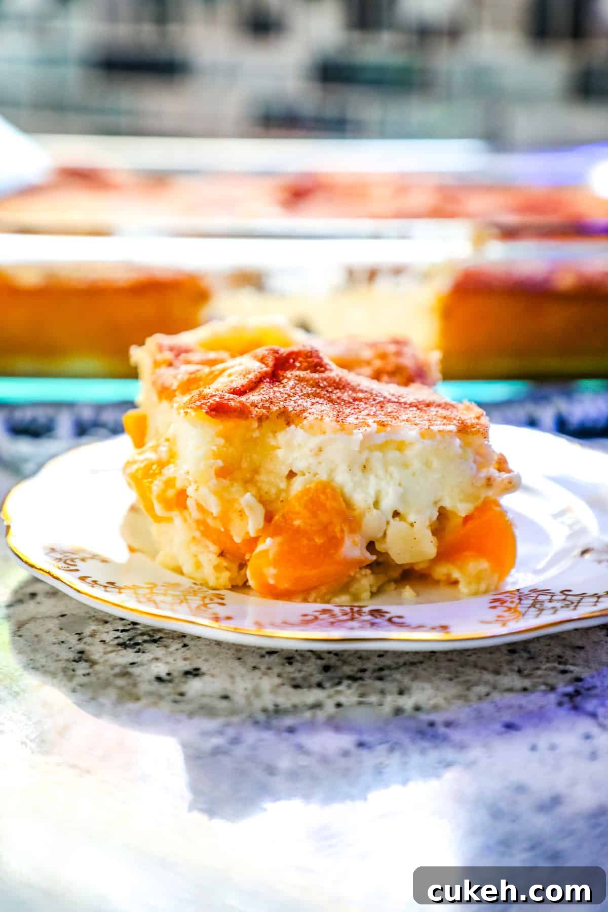 a peaches and cream sheet cake topped with cream cheese, cinnamon, and sugar.