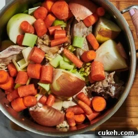 Turkey stock with carrots, onions, and bones in large stock pot.
