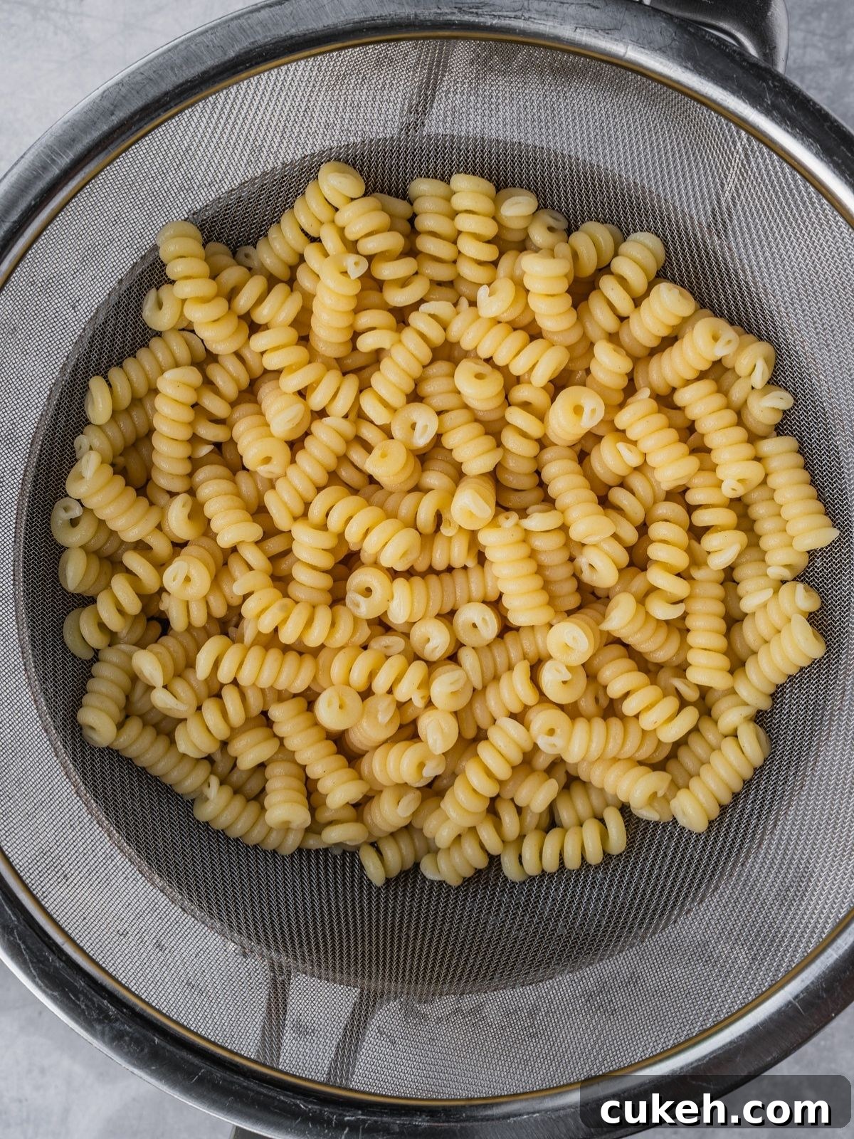 Cooked pasta draining in a colander.