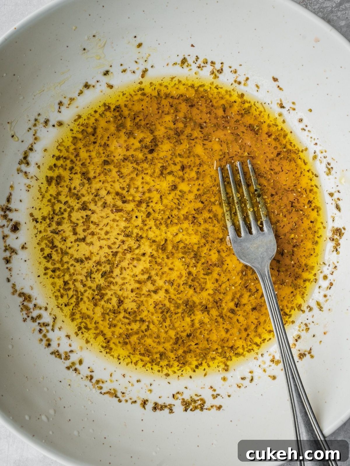 Recipe step showing the mixing of the salad dressing directly in the serving bowl.