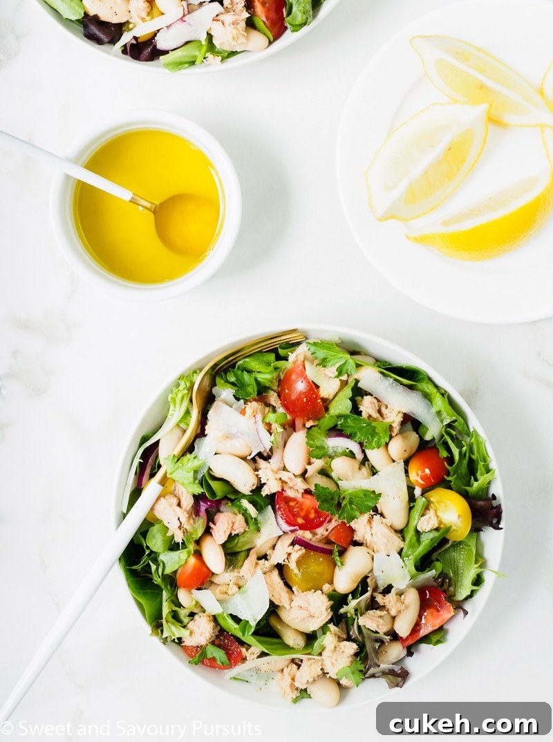 A bowl of White Bean and Tuna Salad served with a lemon and olive oil dressing on the side.