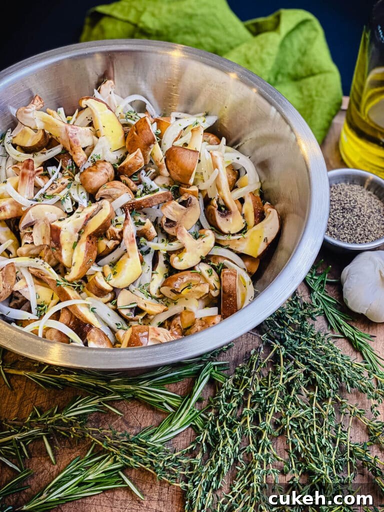 mushrooms and onions drizzled with olive oil and tossed with herbs in a bowl