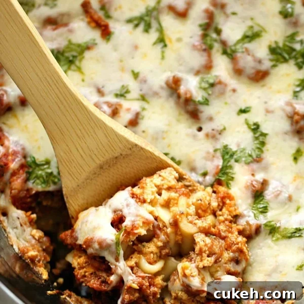 Lasagna in the slow cooker being dished out with wooden spoon