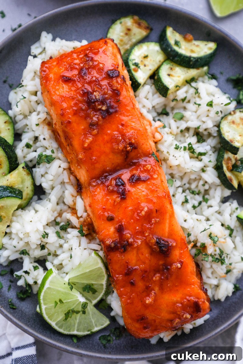 A fillet of chipotle maple air fried salmon served over cilantro lime rice with lime wedges on the side
