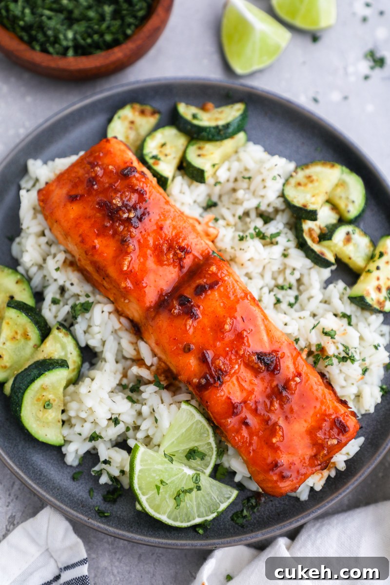A plate of cilantro lime rice and sautéed zucchini served with a chipotle salmon fillet on top