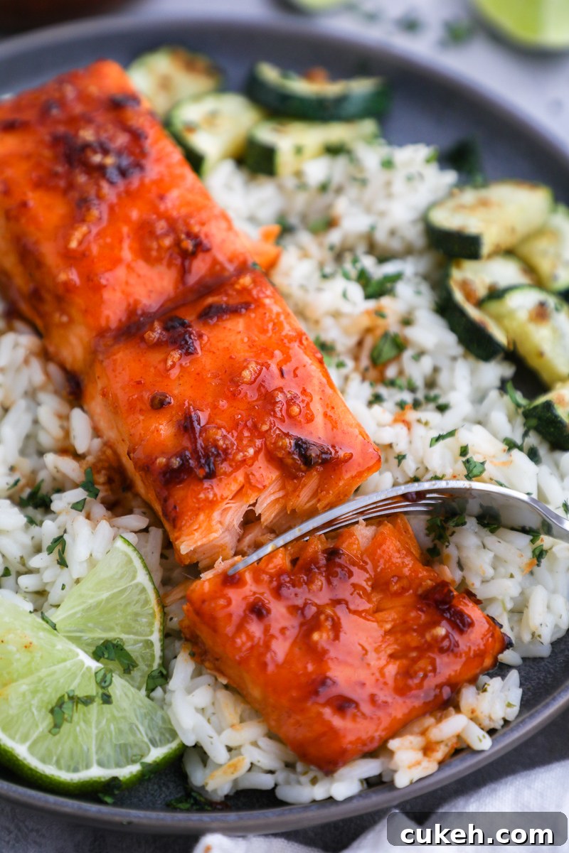 A fork digging into a fillet of chipotle maple salmon showing it's flakey texture