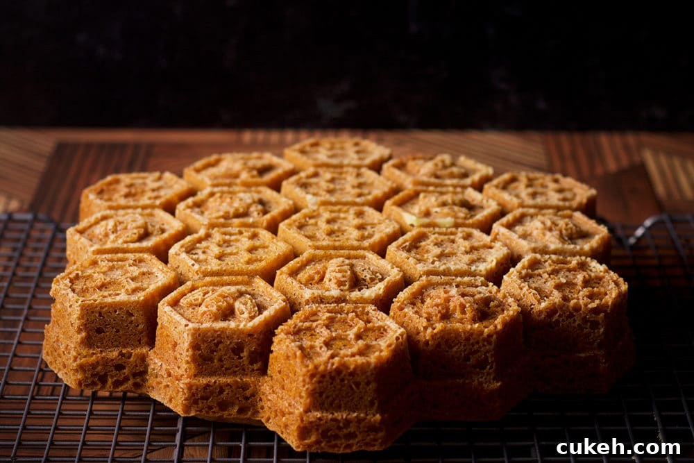 A honey almond cake that's been baked in a honeycomb pan, cooling on a wire rack.