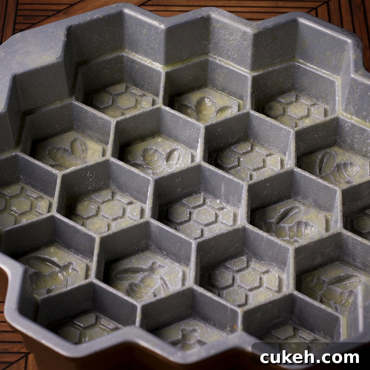A honeycomb pan that has been sprayed with non-stick baking spray and dusted with flour.