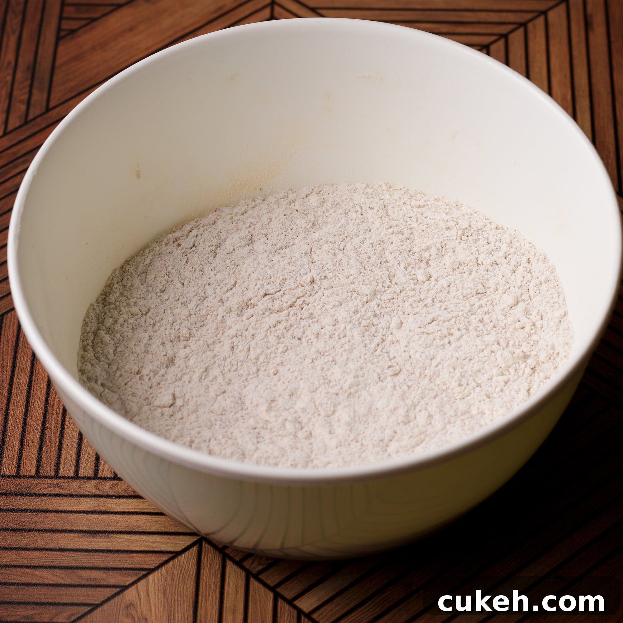 All the dry ingredients for honey cake blended together in a white bowl.