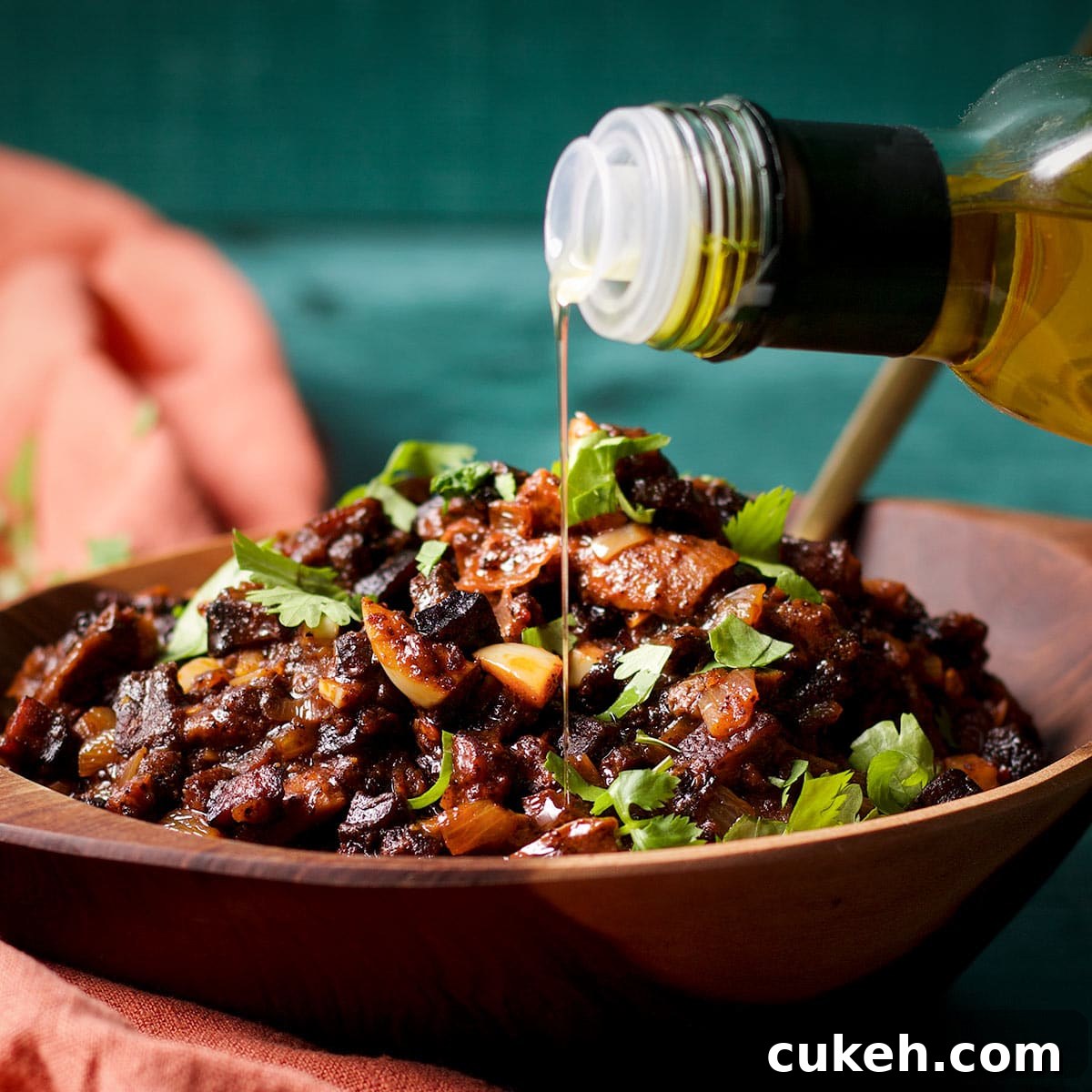 Drizzling truffle oil over the top of a bowl of mushroom ragu.