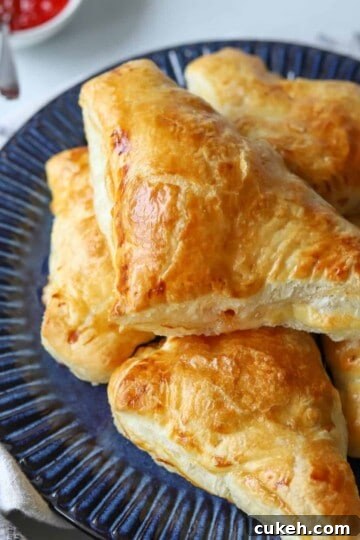 bacon and cheese turnovers on blue plate with side of pepper jelly