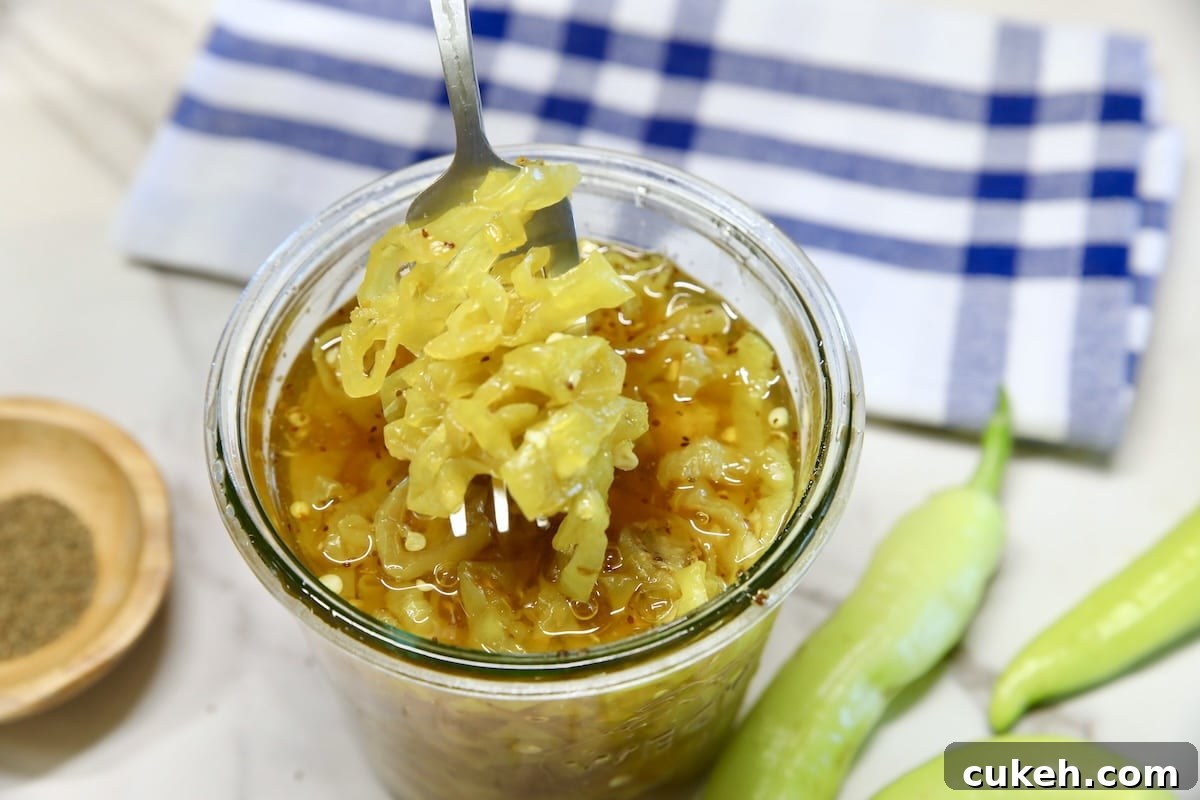 Jar of candied banana peppers with fork. 