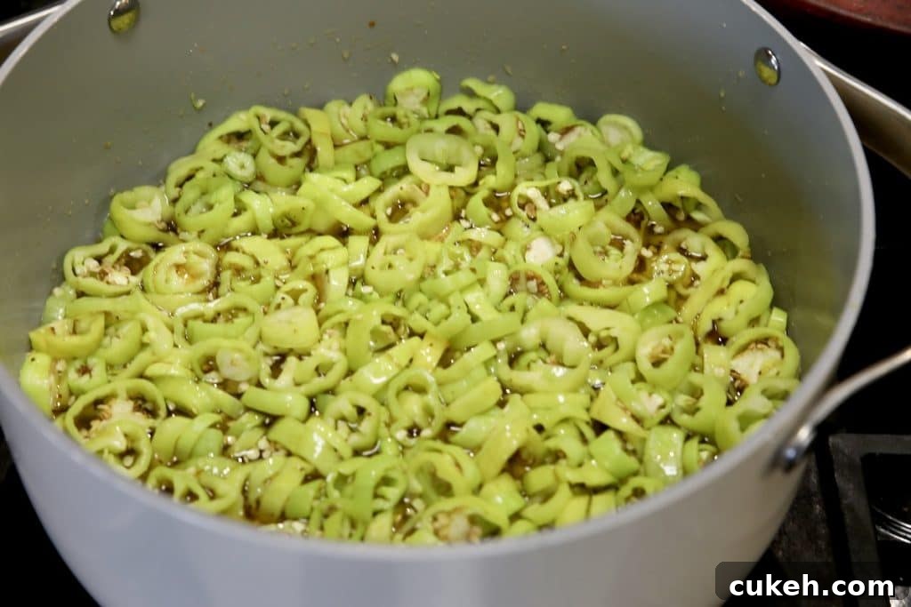 Sliced banana peppers in a pan with brine.
