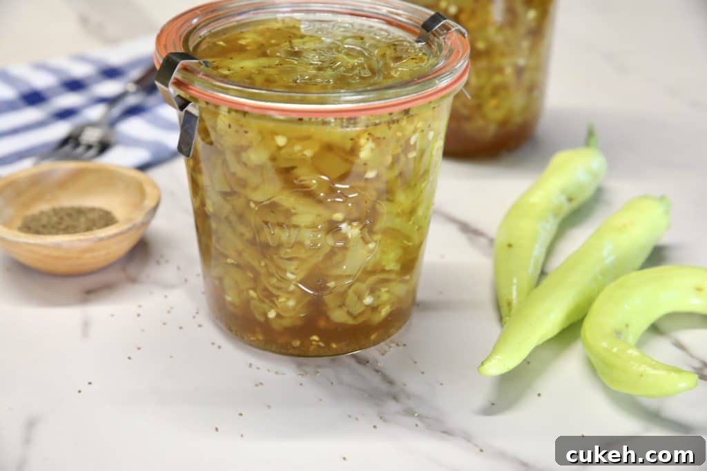 Jar of banana peppers, peppers on the side.