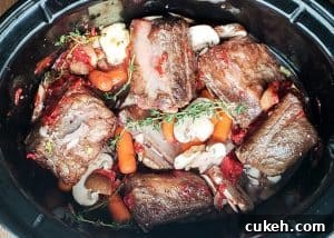Prep image for crockpot beef short ribs recipe showing ingredients in a crockpot uncooked.
