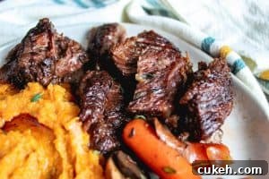 Close up shot of beef short ribs on a white plate.