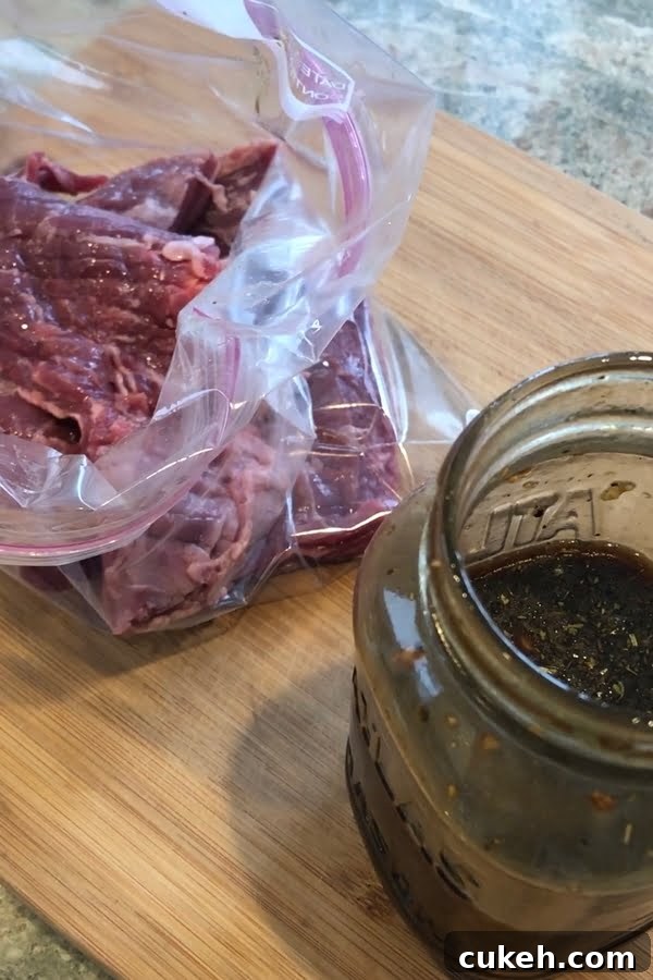 Savory Balsamic Steak Marinade for Tender, Flavorful Grilling 3 A marinating steak in a resealable bag on a cutting board.