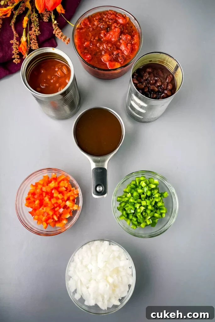 chili beans, black beans, beef broth, chopped green peppers, chopped red peppers, fire roasted tomatoes, and chopped onions in separate bowls