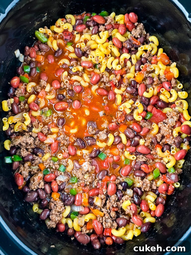 uncooked chili mac and cheese in a slow cooker