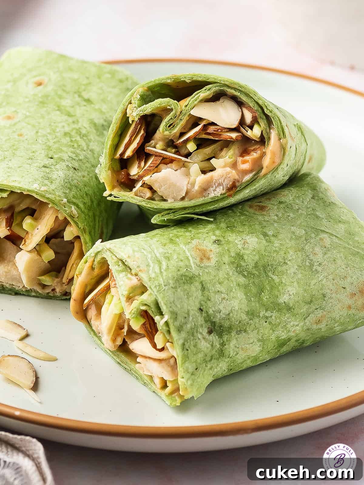 BBQ Chicken Wrap in spinach tortilla sliced in half on plate