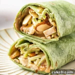 BBQ Chicken Wrap in spinach tortilla sliced in half on plate