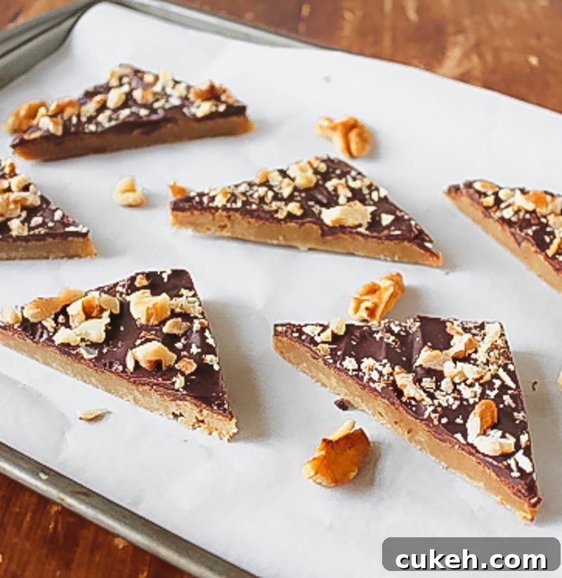 toffee bars cut into triangles spread apart on parchment lined baking sheet